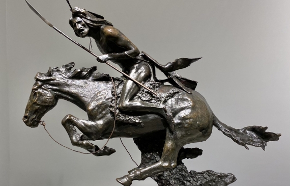 Alt text: Bronze sculpture of a Cheyenne warrior holding a spear on horseback