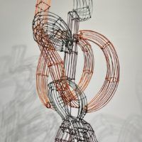 Alt text: Abstract wire sculpture of a hitchhiker