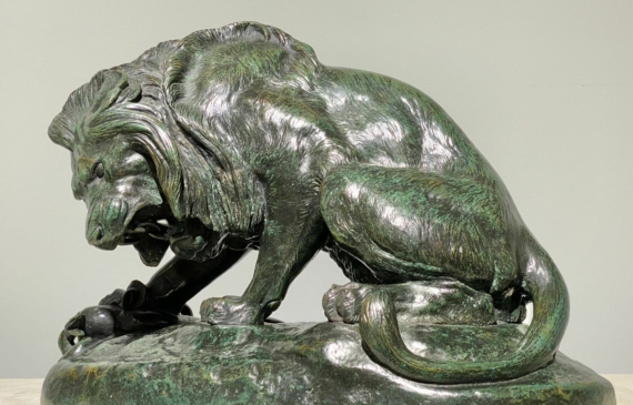 Alt text: Bronze sculpture of a lion and a serpent