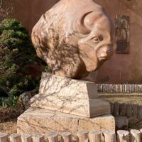 Alt text: Bronze sculpture of a bison, outdoor view