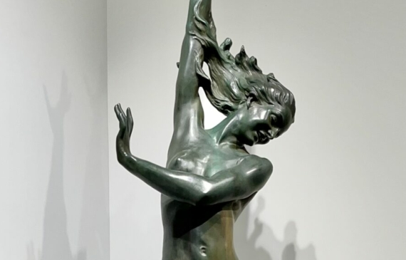 Alt text: Bronze sculpture of a woman standing on a wave