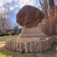 Alt text: Bronze sculpture of a bison, outdoor view
