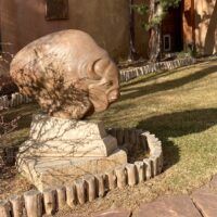 Alt text: Bronze sculpture of a bison, outdoor view