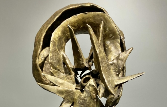Alt text: Abstracted bronze sculpture with rounded top on a marble base