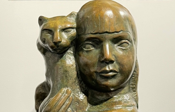 Alt text: Bronze sculpture of a girl and cat