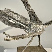 Alt text: Abstract bronze sculpture of a bird