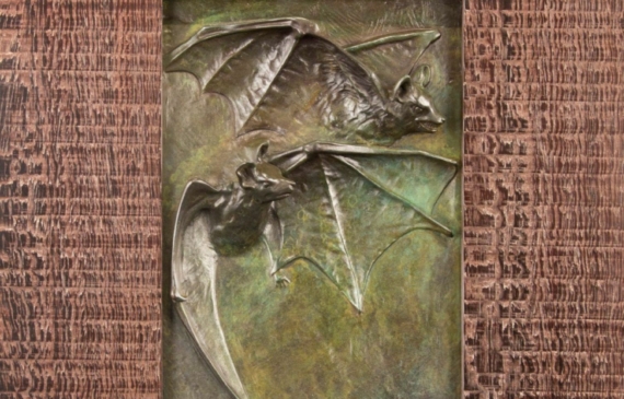 Alt text: Relief of two flying bats