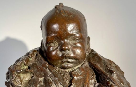 Alt text: Bronze sculpture of a baby