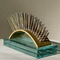 Alt text: metal sculpture with spikes on glass base