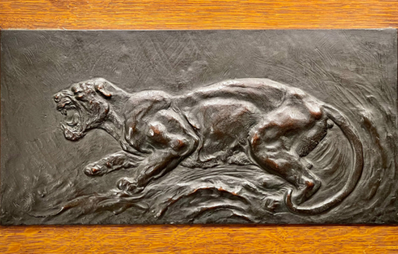 Alt text: Bronze relief of a panther