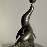 Alt text: Bronze sculpture of a seal with a ball