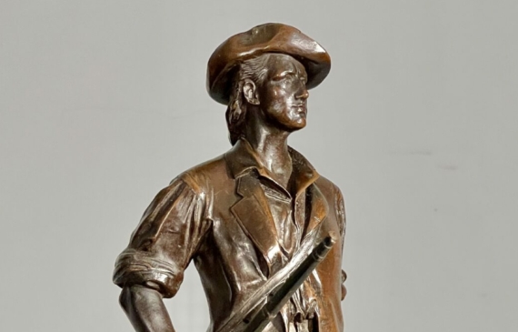 Alt text: Bronze sculpture of a man with a gun