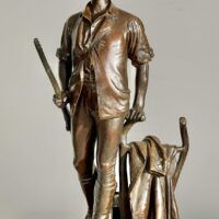 Alt text: bronze sculpture of a man with a gun