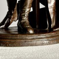 Alt text: bronze sculpture, title inscription detail