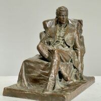 Alt text: Bronze sculpture of a seated man