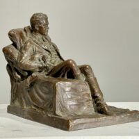 Alt text: Bronze sculpture of a seated man