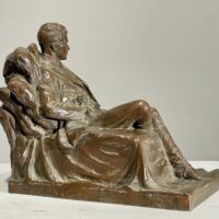 Alt text: Bronze sculpture of a seated man