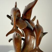 Alt text: Bronze sculpture of a group of dolphins