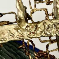 Alt text: Abstract metal sculpture, signature detail