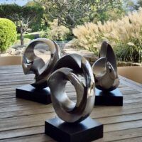 Alt text: Trio of rounded stainless steel sculptures