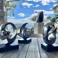 Alt text: Trio of rounded stainless steel sculptures