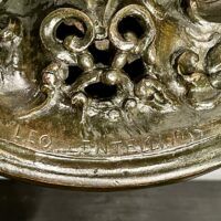 Alt text: signature detail on base of a bronze sculpture