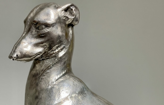 Alt text: Silvered bronze sculpture of a seated dog