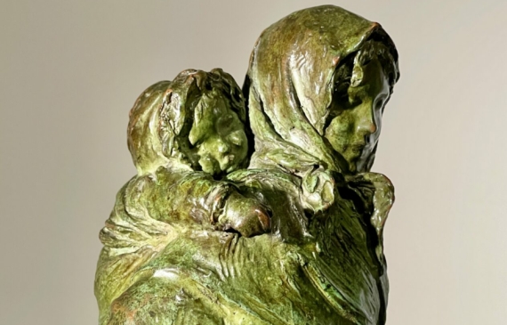 Alt text: Bronze sculpture of woman with child on her back