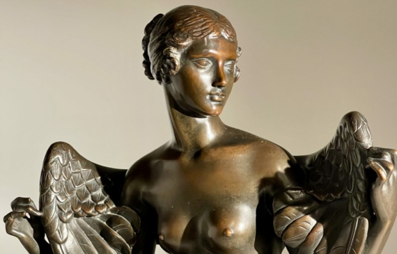 Alt text: Bronze sculpture of Philomela from Greek mythology, kneeling with wings growing from her back