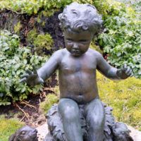 Alt text: Bronze outdoor sculpture of a child with two rabbits