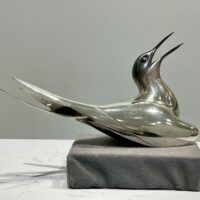 Alt text: Sculpture of a bird with a silver finish