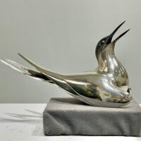 Alt text: Sculpture of a bird with a silver finish