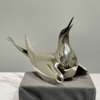 Alt text: Sculpture of a bird with a silver finish