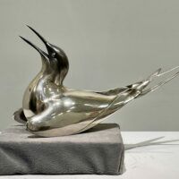 Alt text: Sculpture of a bird with a silver finish