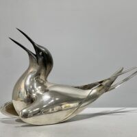 Alt text: Sculpture of a bird with a silver finish