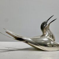 Alt text: Sculpture of a bird with a silver finish