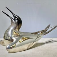 Alt text: Sculpture of a bird with a silver finish