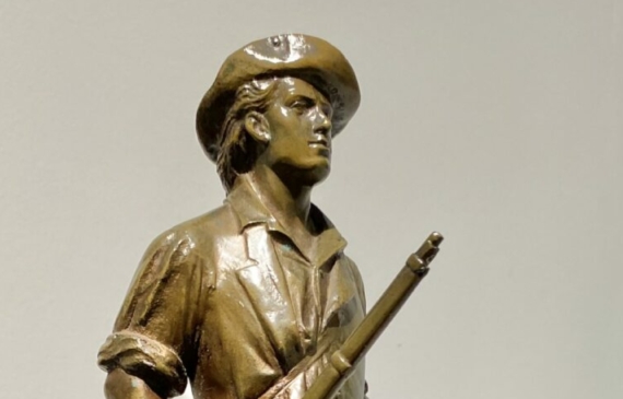 Alt text: Bronze sculpture of a man with a rifle