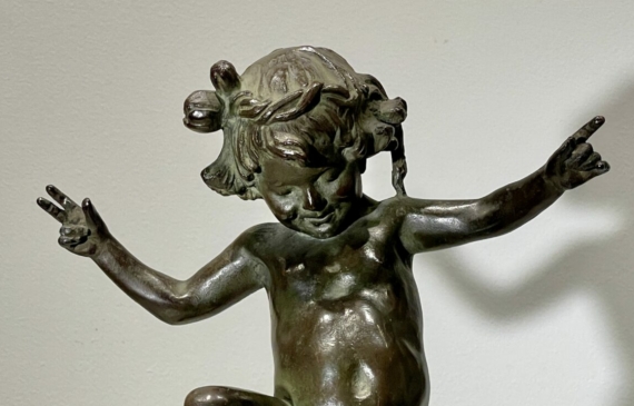 Alt text: Bronze sculpture of a skipping toddler