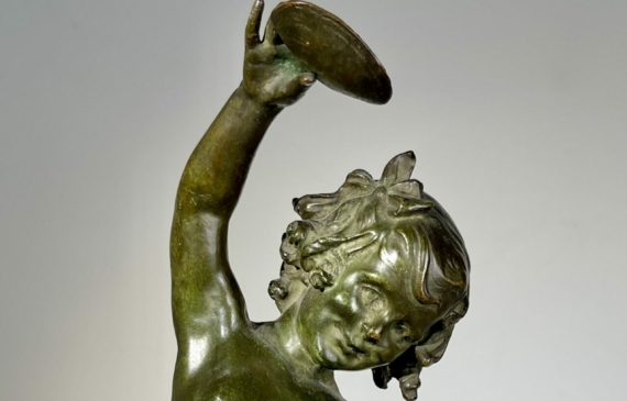 Alt text: Bronze sculpture of a child holding a seashell