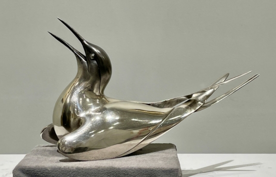 Alt text: Sculpture of a bird with a silver finish