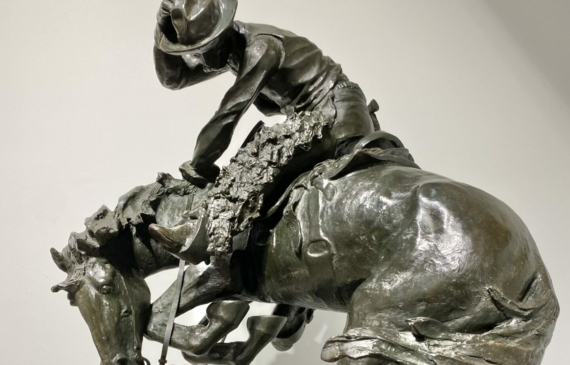 Alt text: Bronze sculpture of a cowboy atop a scared horse startled by a rattlesnake