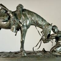 Alt text: Bronze sculpture of a figure kneeling in front of a horse