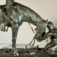 Alt text: Bronze sculpture of a figure kneeling in front of a horse