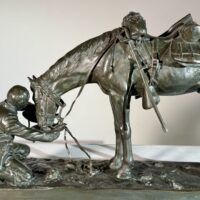 Alt text: Bronze sculpture of a figure kneeling in front of a horse