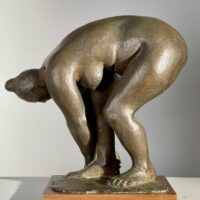 Alt text: Bronze sculpture of a nude woman bending over