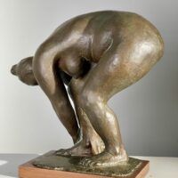 Alt text: Bronze sculpture of a nude woman bending over