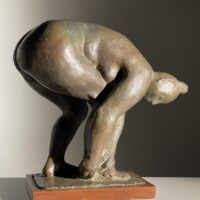 Alt text: Bronze sculpture of a nude woman bending over