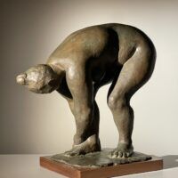 Alt text: Bronze sculpture of a nude woman bending over