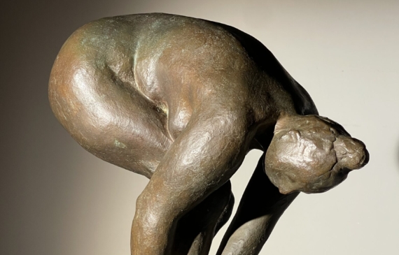 Alt text: Bronze sculpture of a nude woman bending over